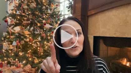 gif of Sarah in Sarah Uncut Episode 28 with one finger pointing up and a christmas tree behind her